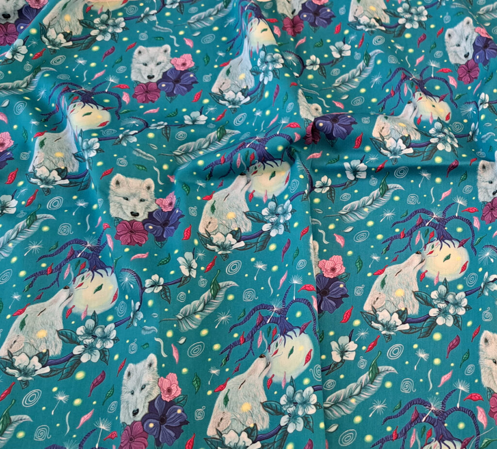 Tissu popeline “Le Souffle de la Louve” légèrement froissé, montrant la souplesse du coton et l’équilibre du motif.